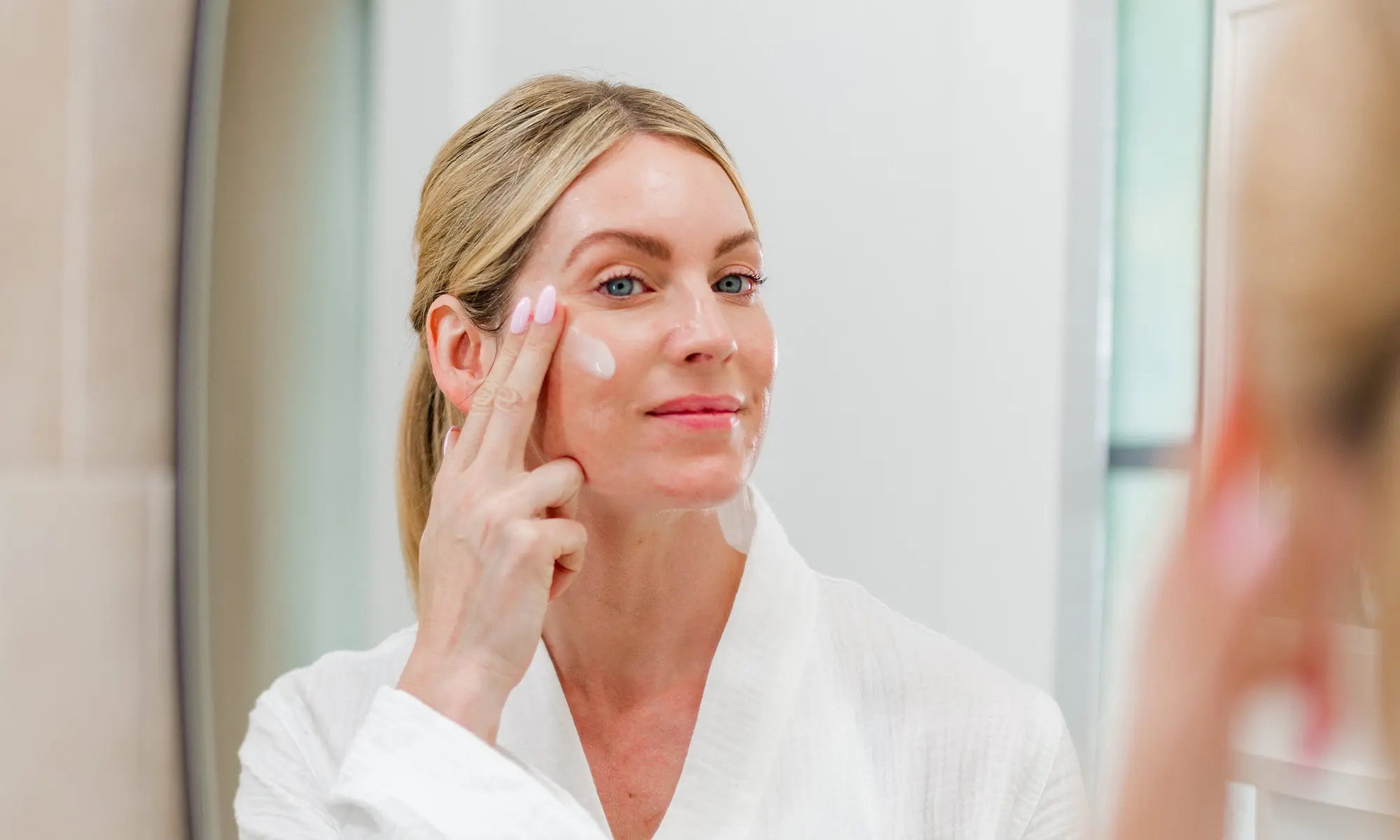 woman applying IMAGE Skincare moisturizer in vanity