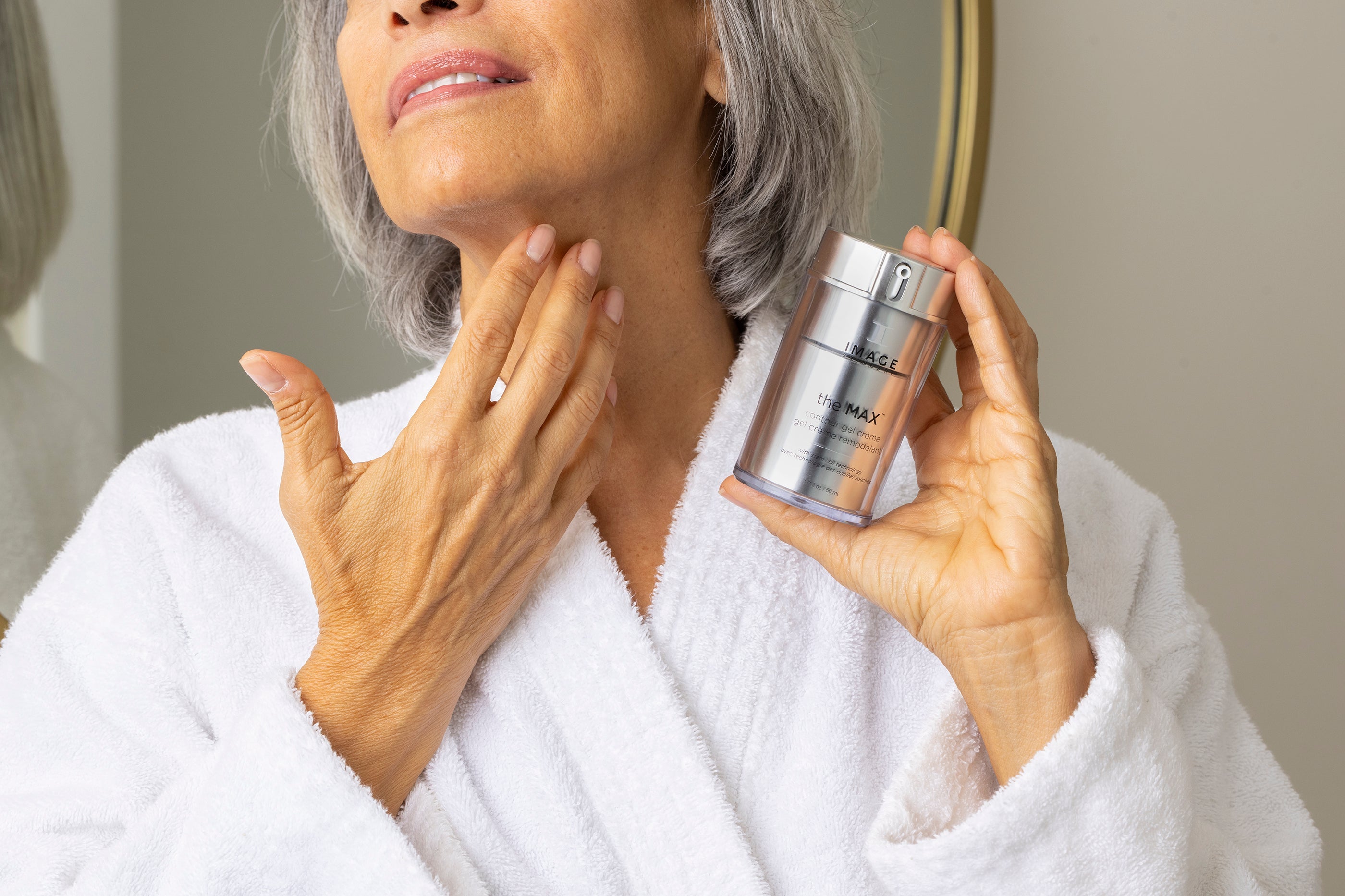 A woman applying The Max Stem Cell Serum to address visible signs of aging.
