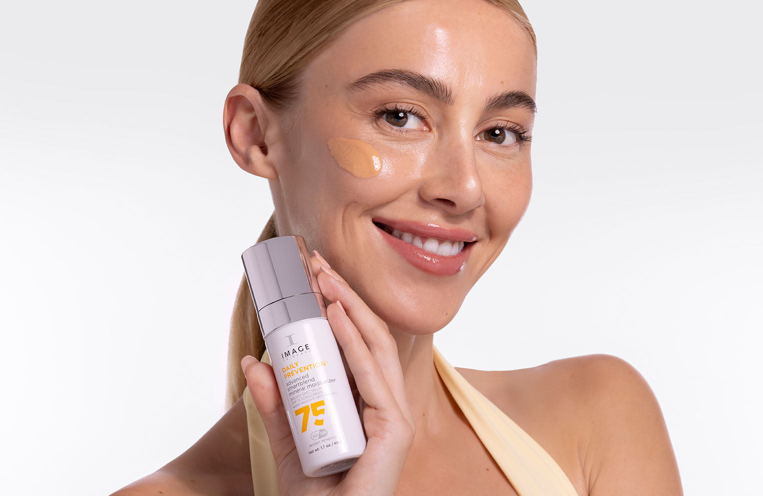 model holding DAILY PREVENTION advanced smartblend SPF 75 up to face