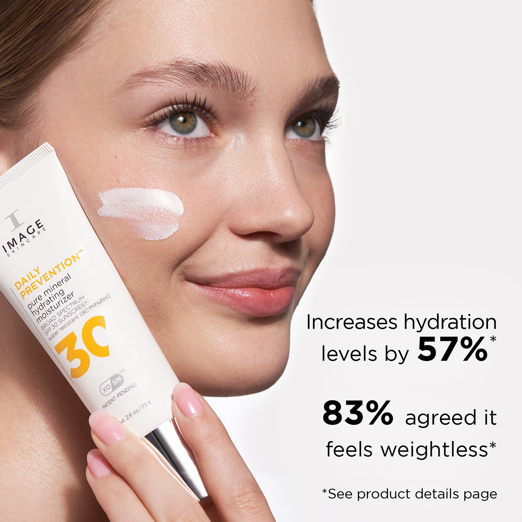 Woman holding a tube of DAILY PREVENTION pure mineral hydrating face moisturizer with sunscreen near her face. Graphic shows product benefits: increases hydration levels by 57%, and 83% of users agreed it feels weightless.