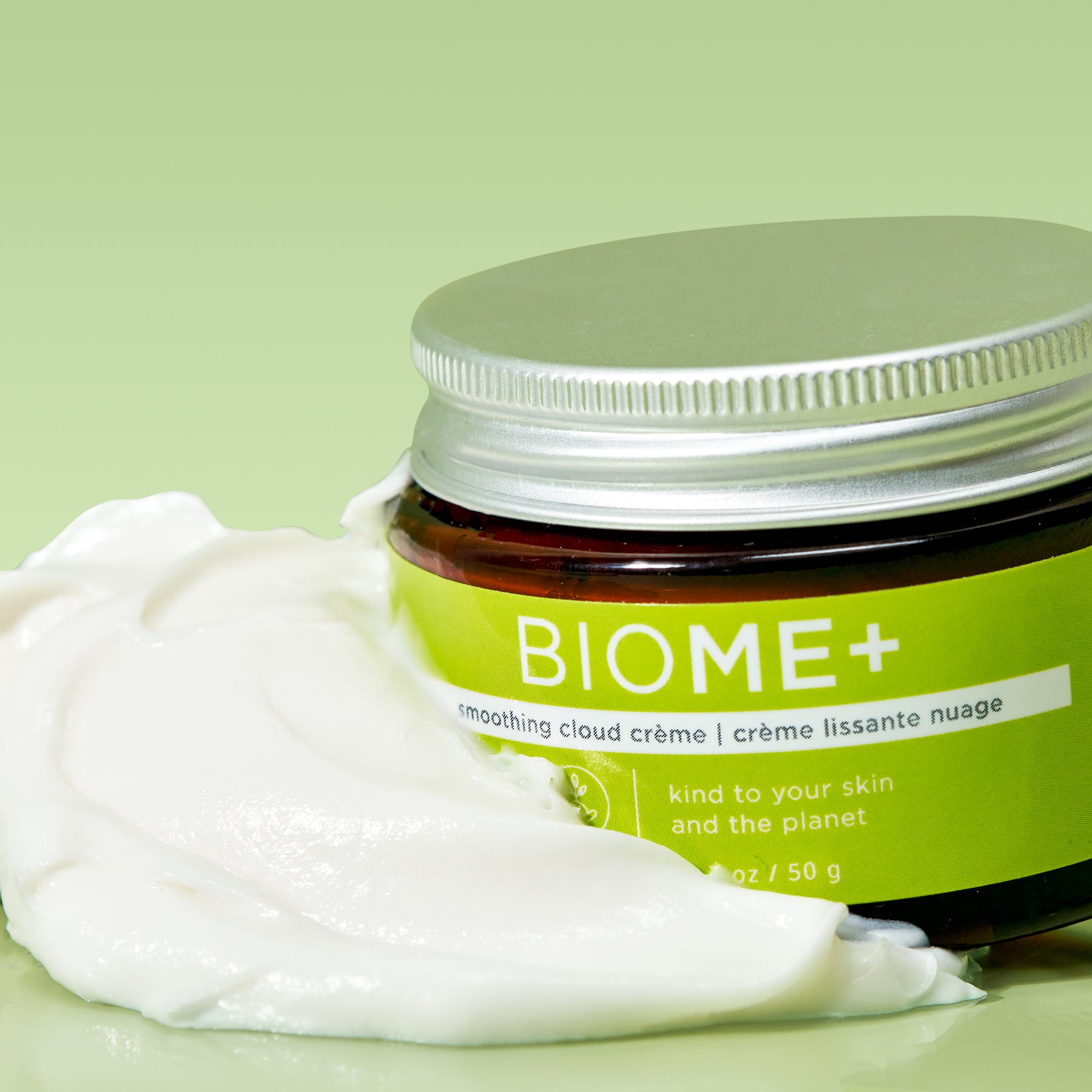 BIOME+ smoothing cloud creme bottle with product smeared on side on green background