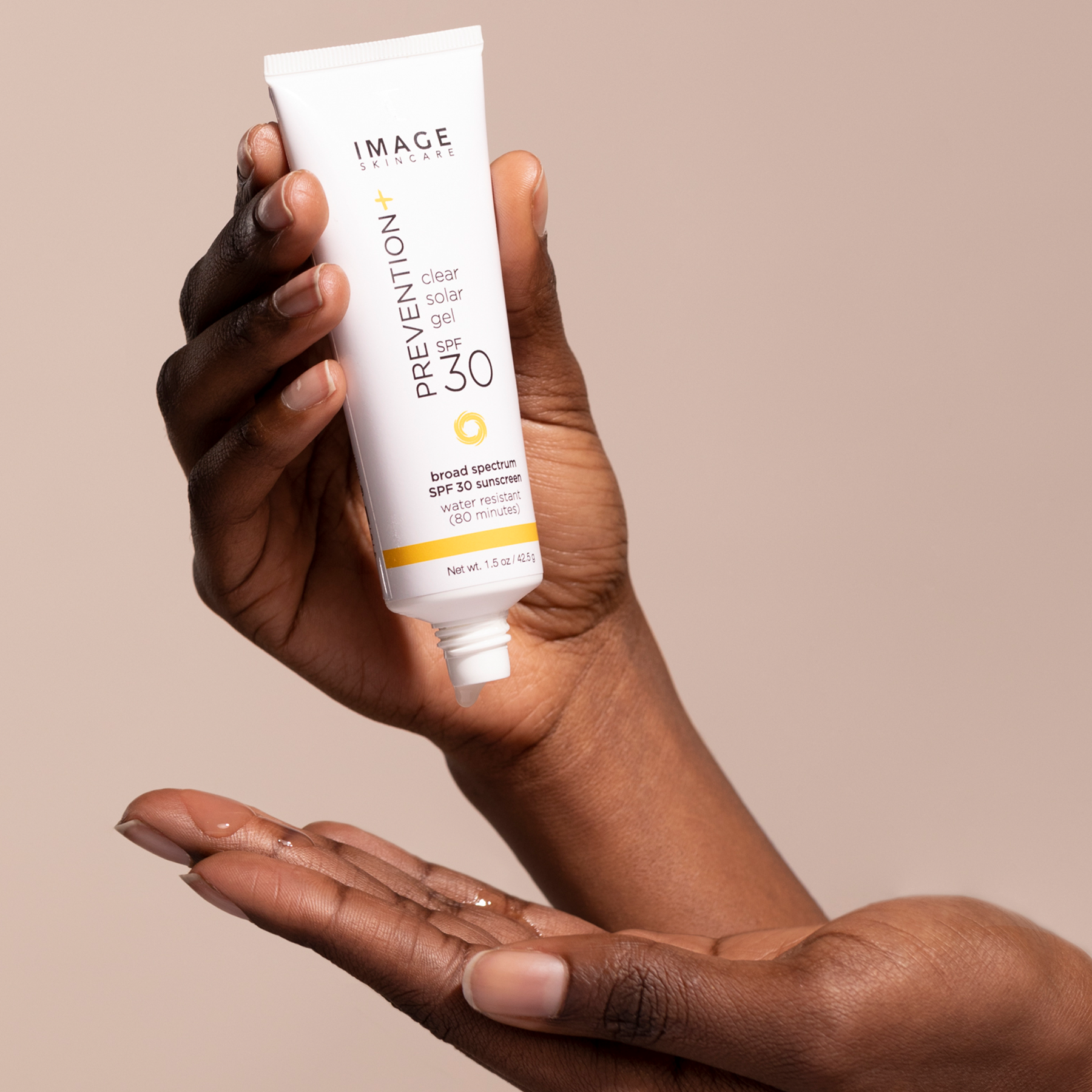 A hand holding the award-winning PREVENTION+ clear sola gel SPF 30 sunscreen.