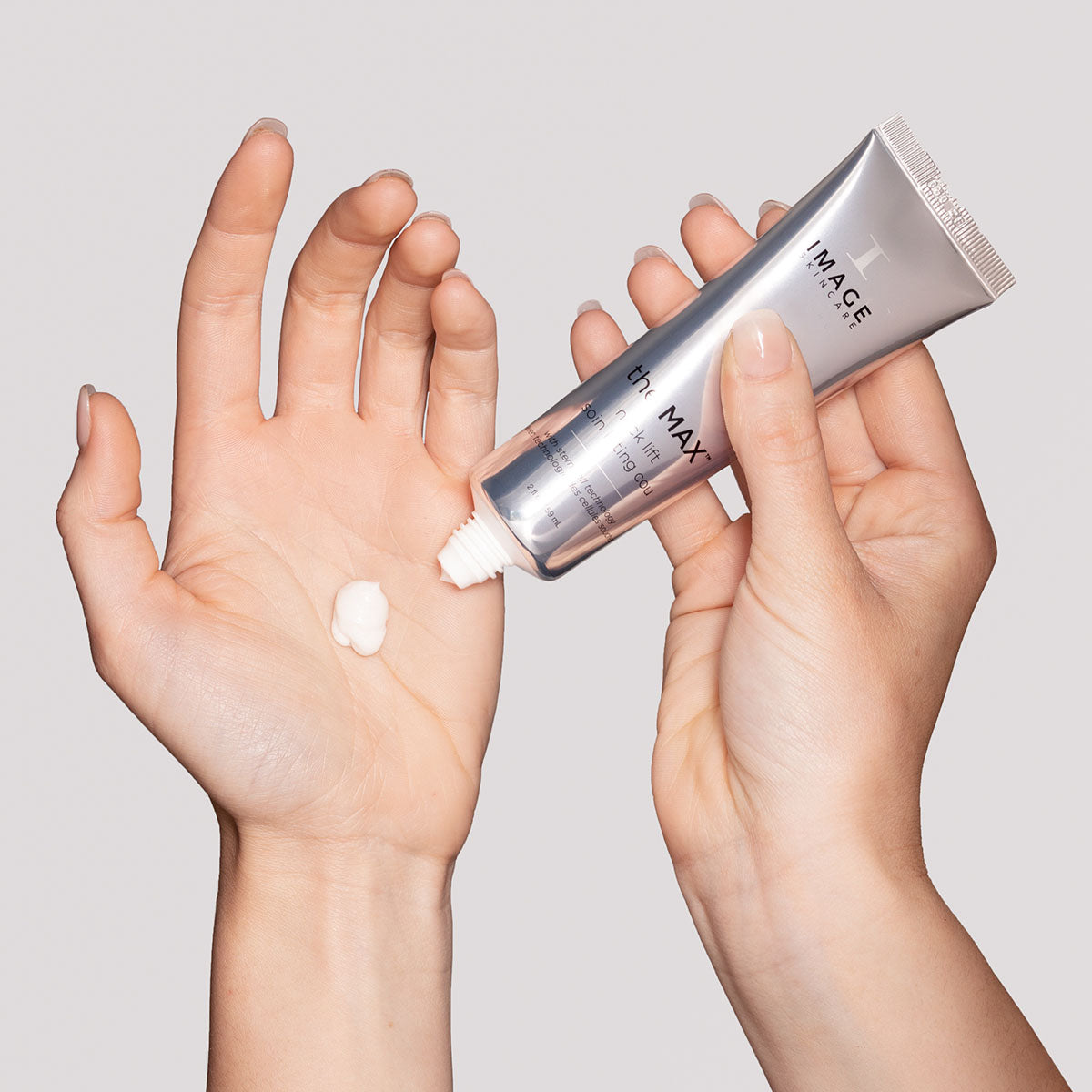 model hand applying neck lift cream to palm