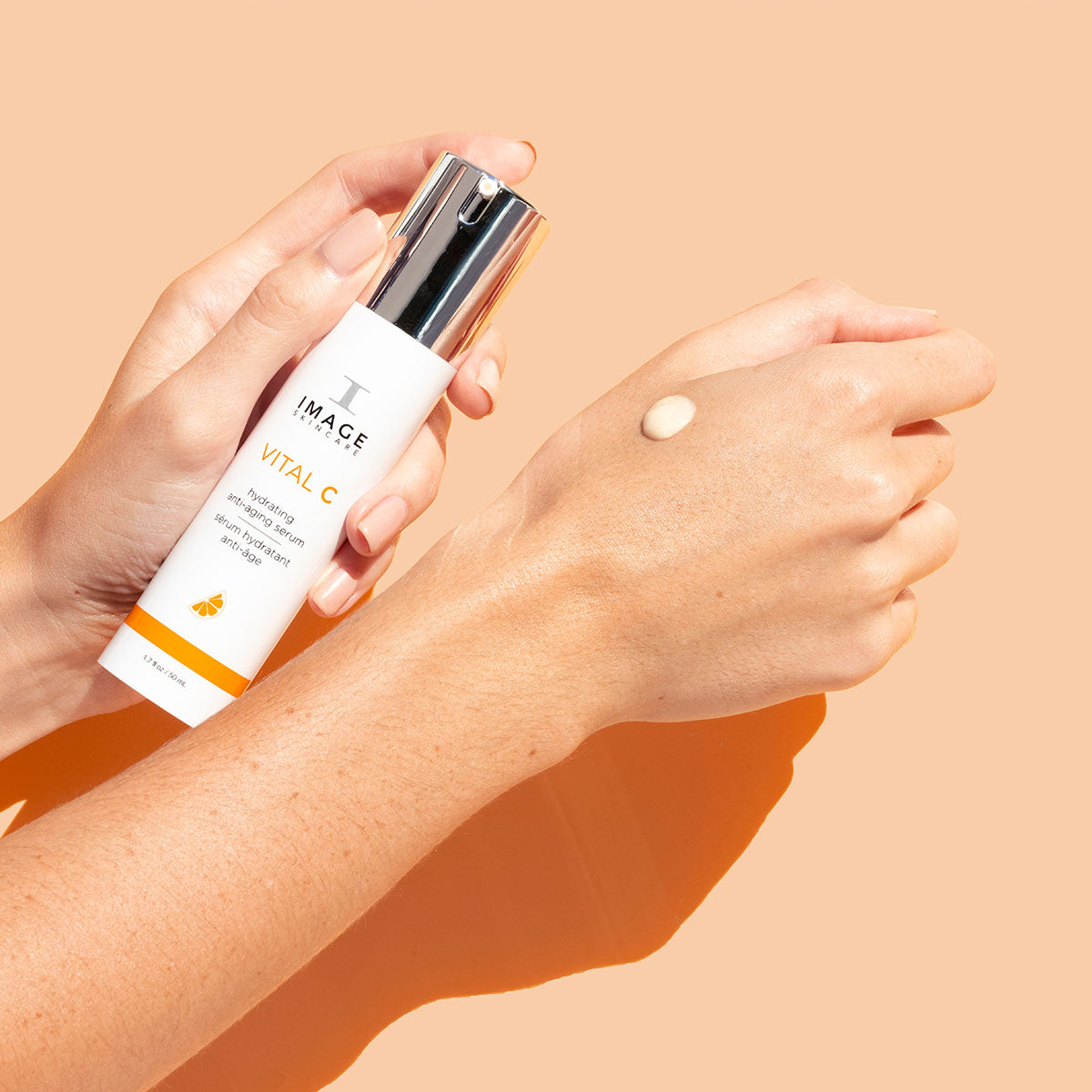 A pair of hands holding the anti aging VITAL C serum by Image Skincare.