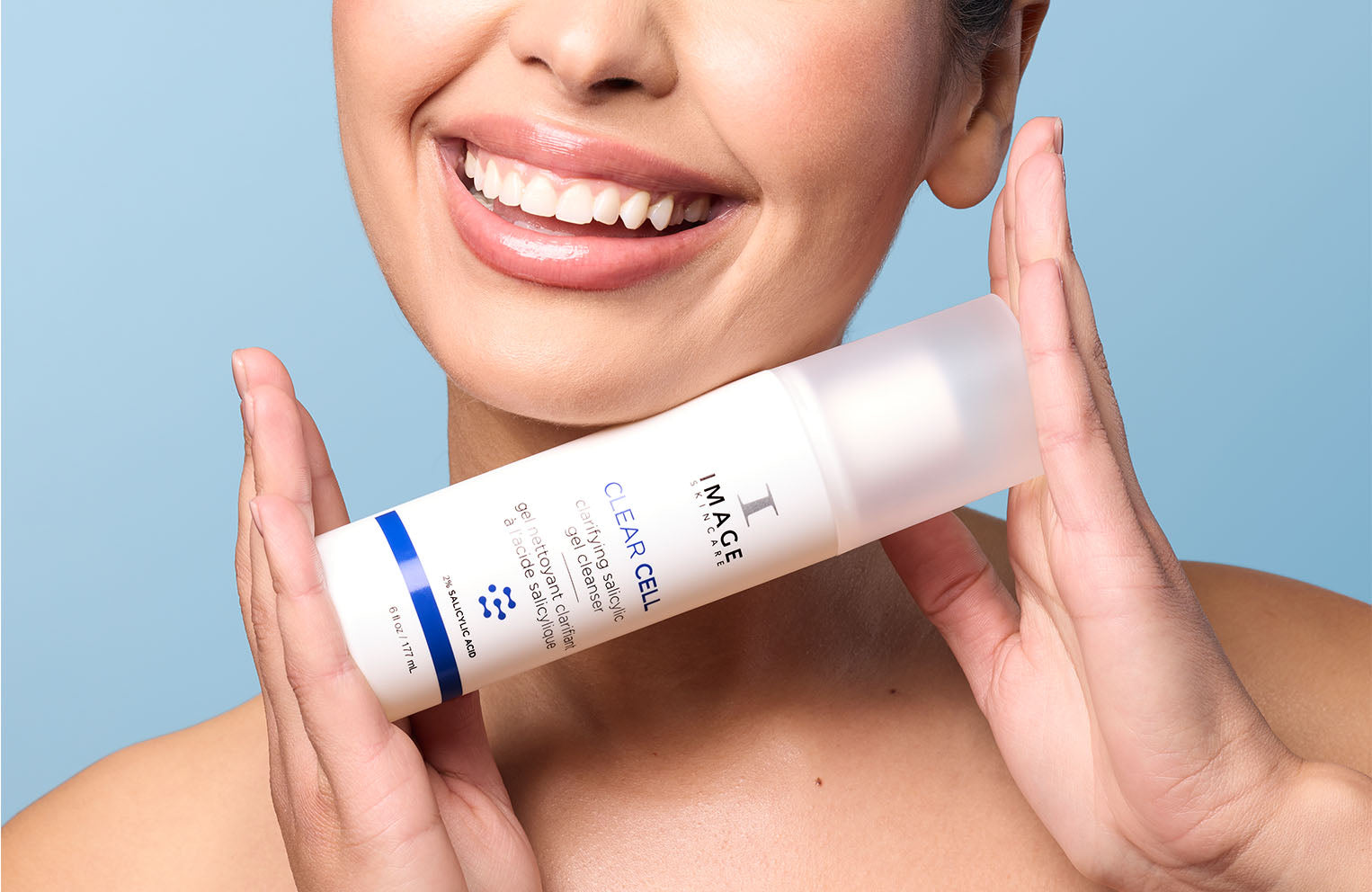 model holding clear cell cleanser under chin