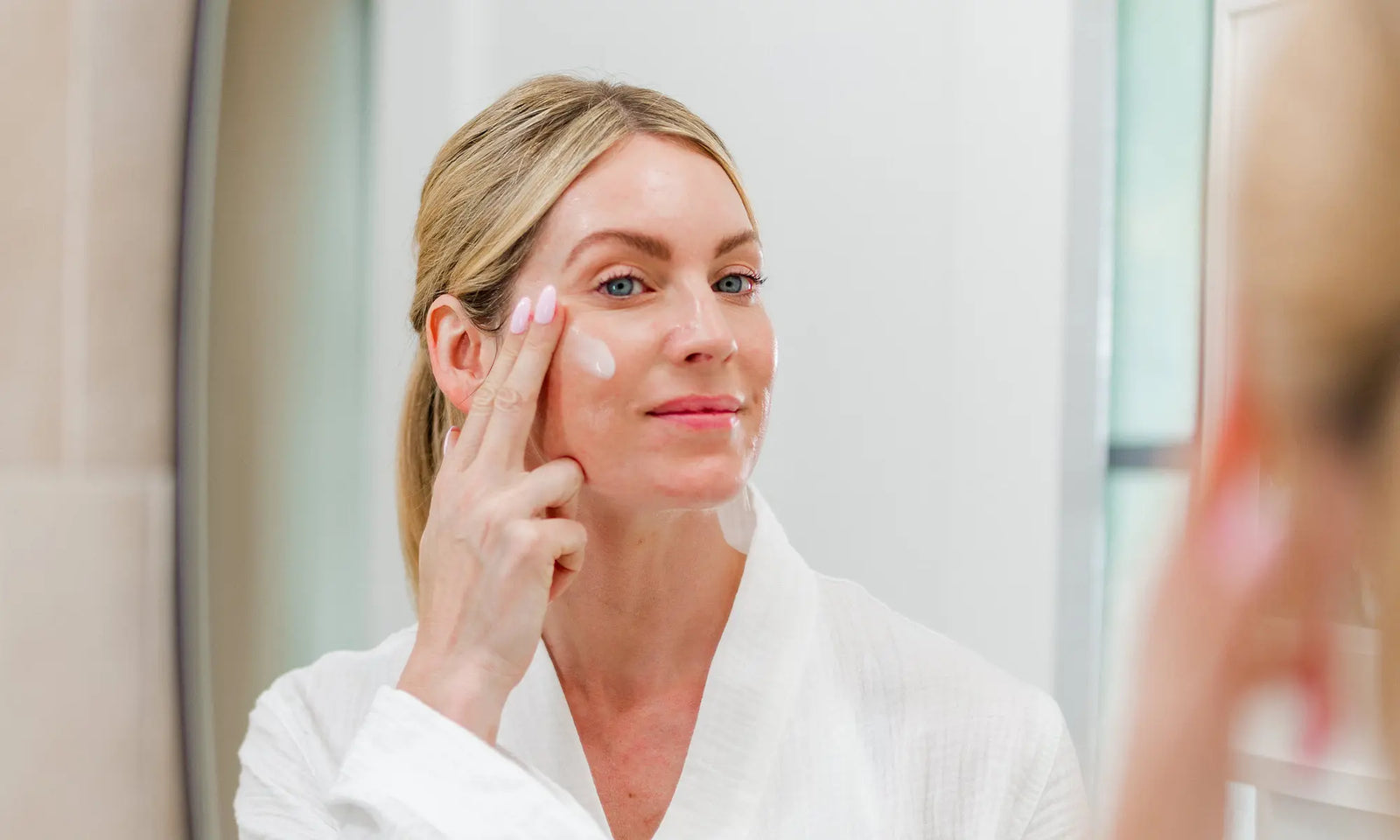 woman applying IMAGE Skincare moisturizer in vanity