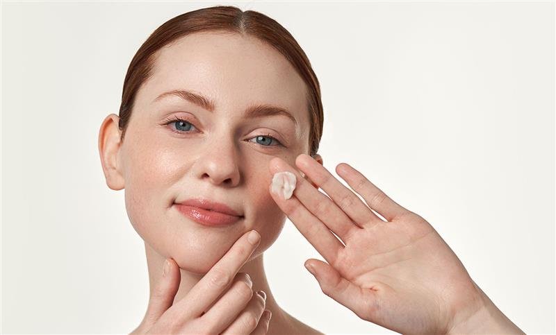 model holding creme swatch in palm against cheek
