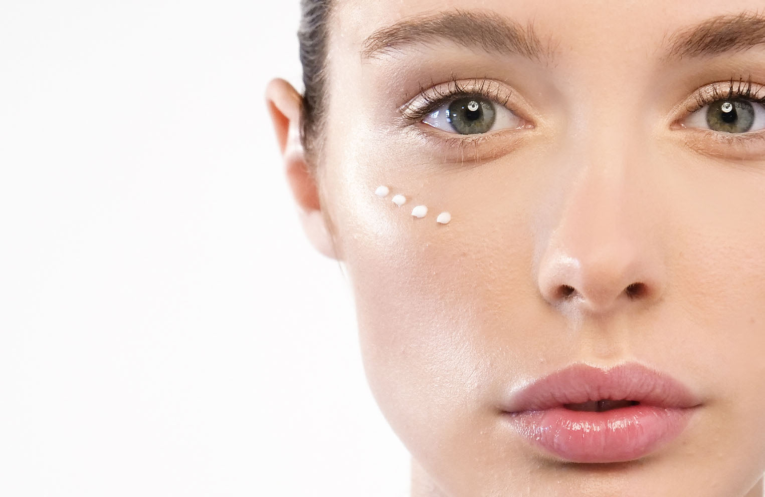 model face with eye cream dots under her eye area