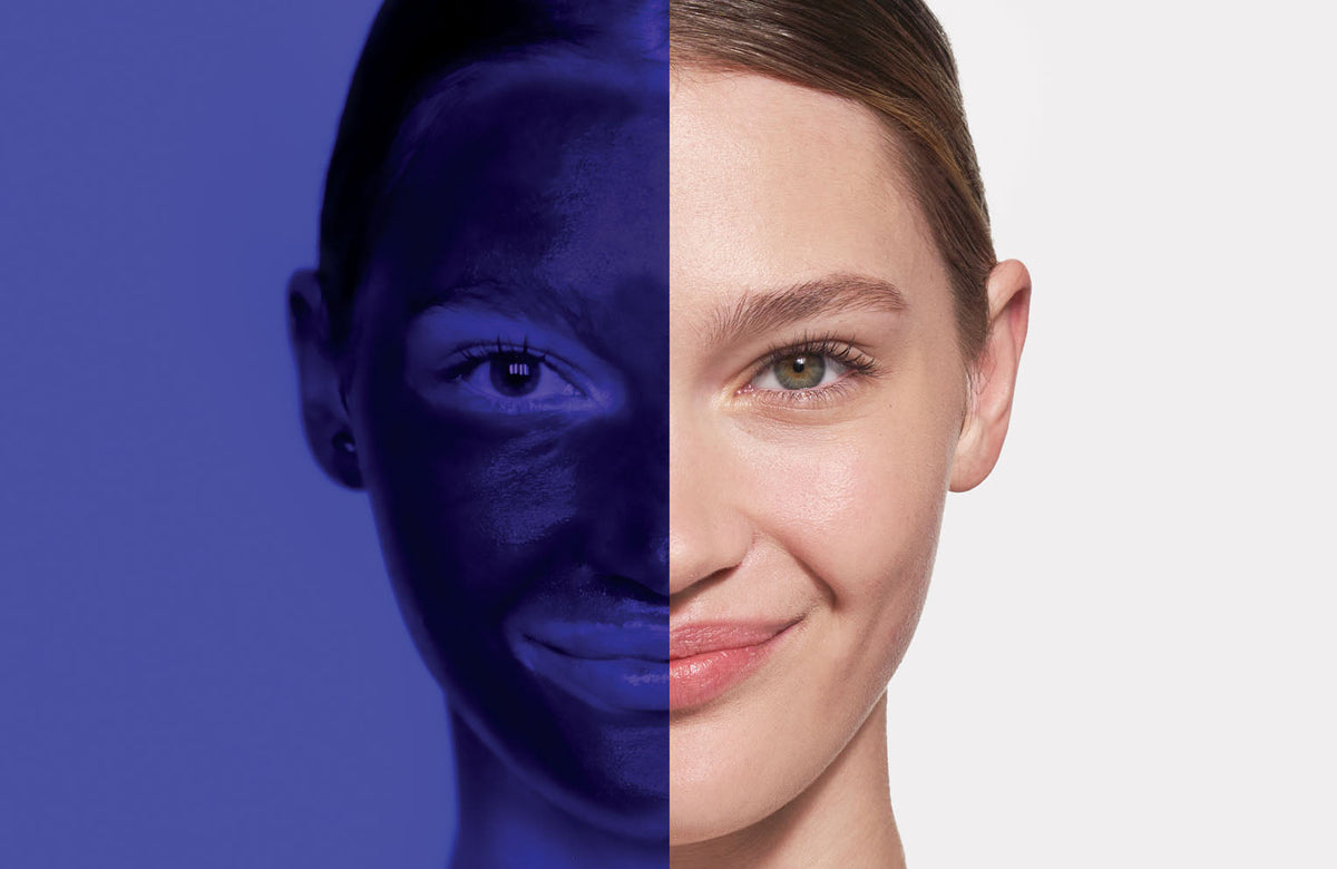 model with half of face under blacklight showing spf application