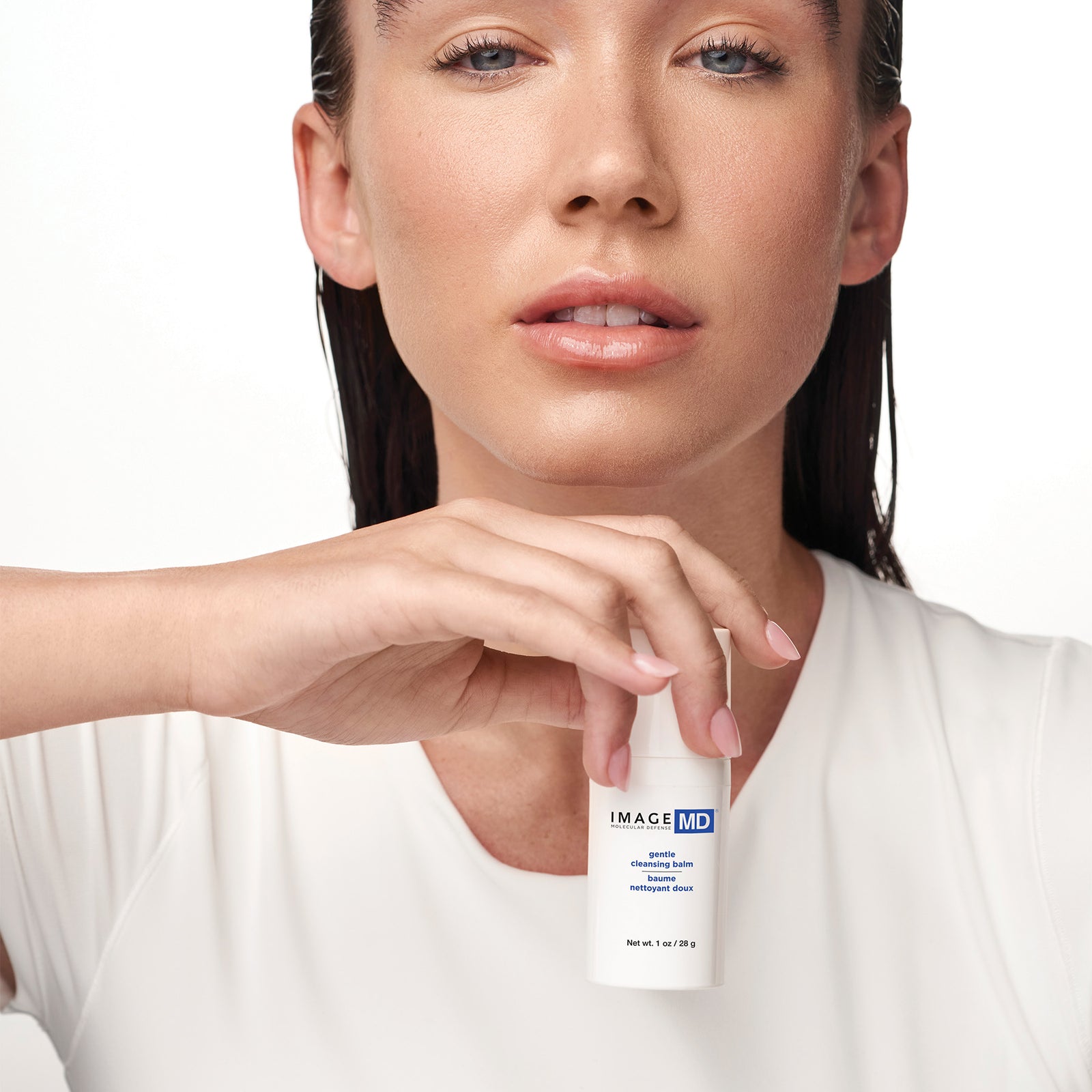 Woman holding a skincare product with 'IMAGE MD' branding against a white background