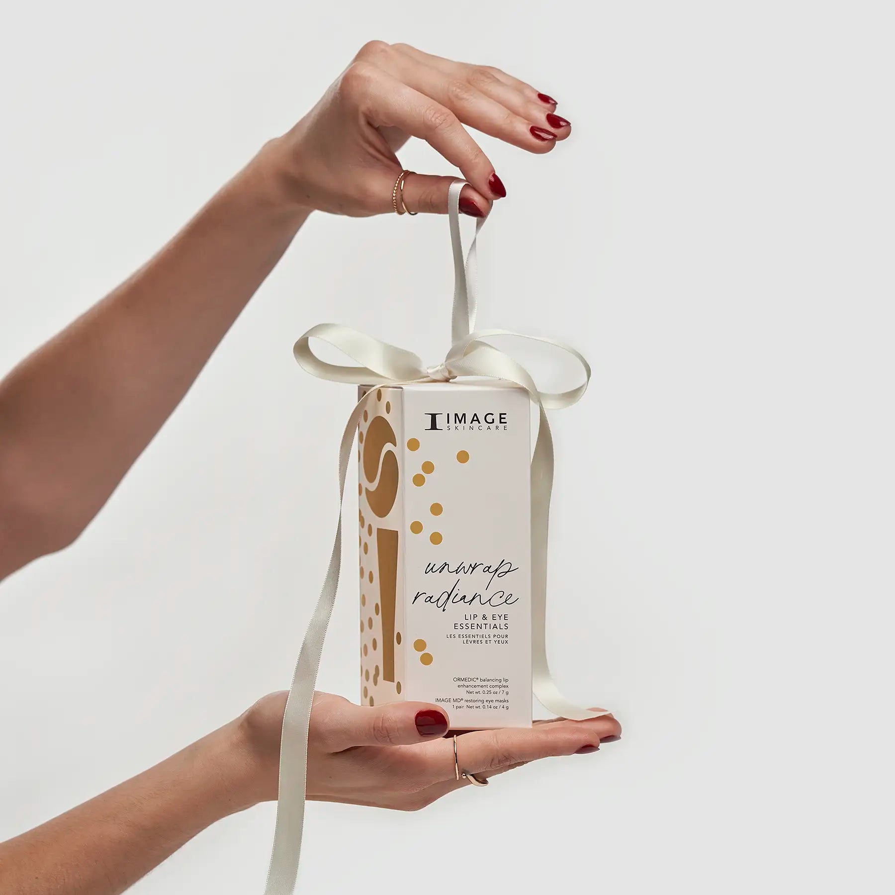 model unwrapping white ribbon on kit packaging 
