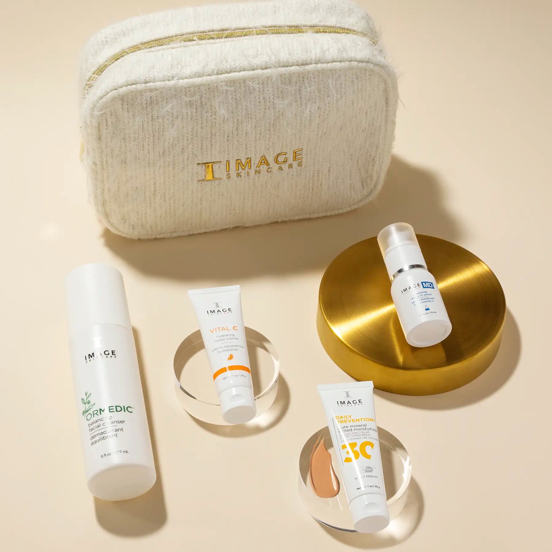 image of all products laying on raised disks in front of cosmetic bag