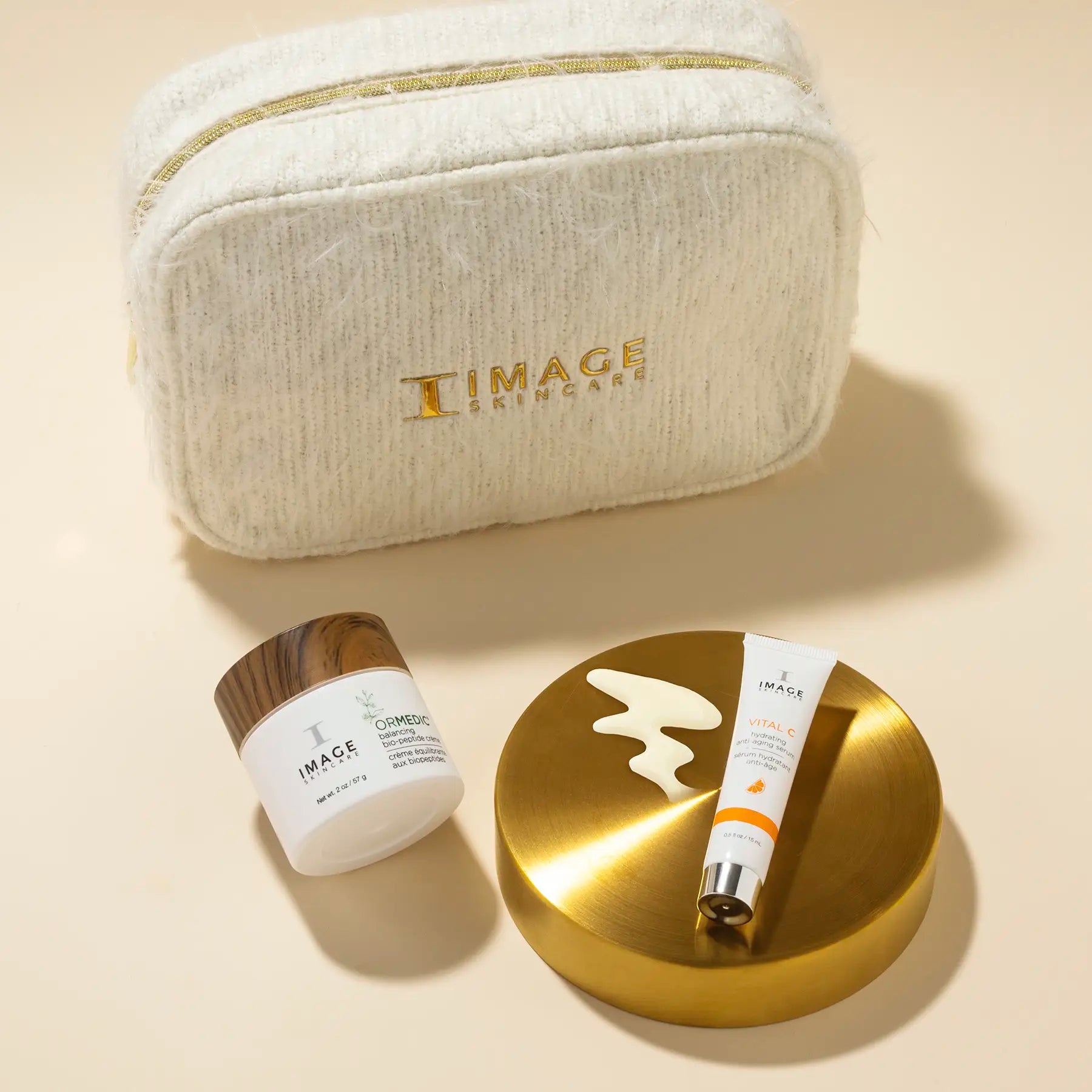 bag ,ormedic biopeptide cream, and VITAL C anti aging serum travel size on a beige background 