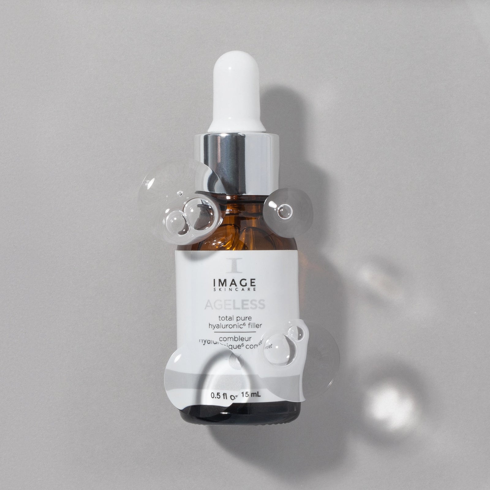 Ageless pure hyaluronic filler bottle on gray background with bubbles