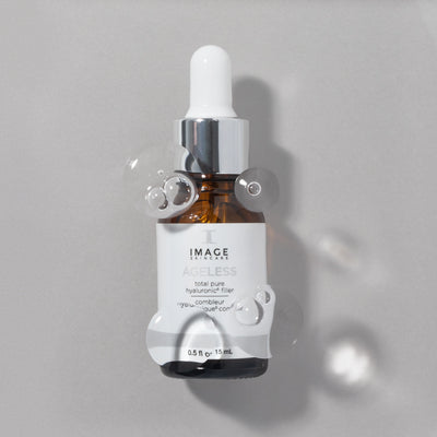 Ageless pure hyaluronic filler bottle on gray background with bubbles