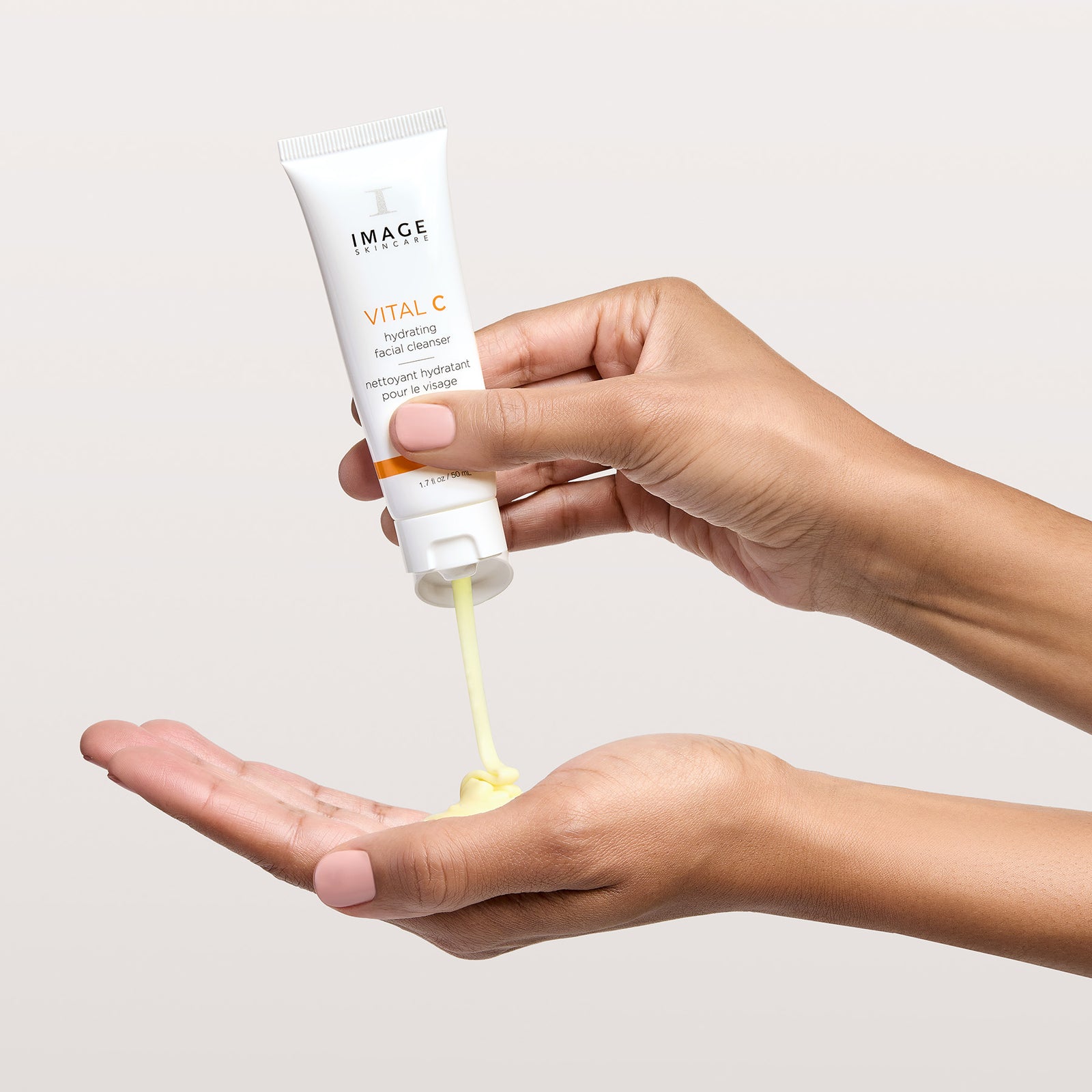 model hands squeezing cleanser onto palm
