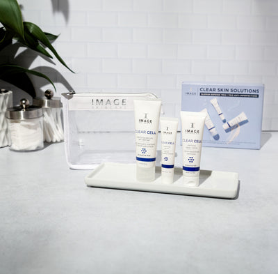 3 kit products on bathroom counter with white mesh bag and kit box behind products
