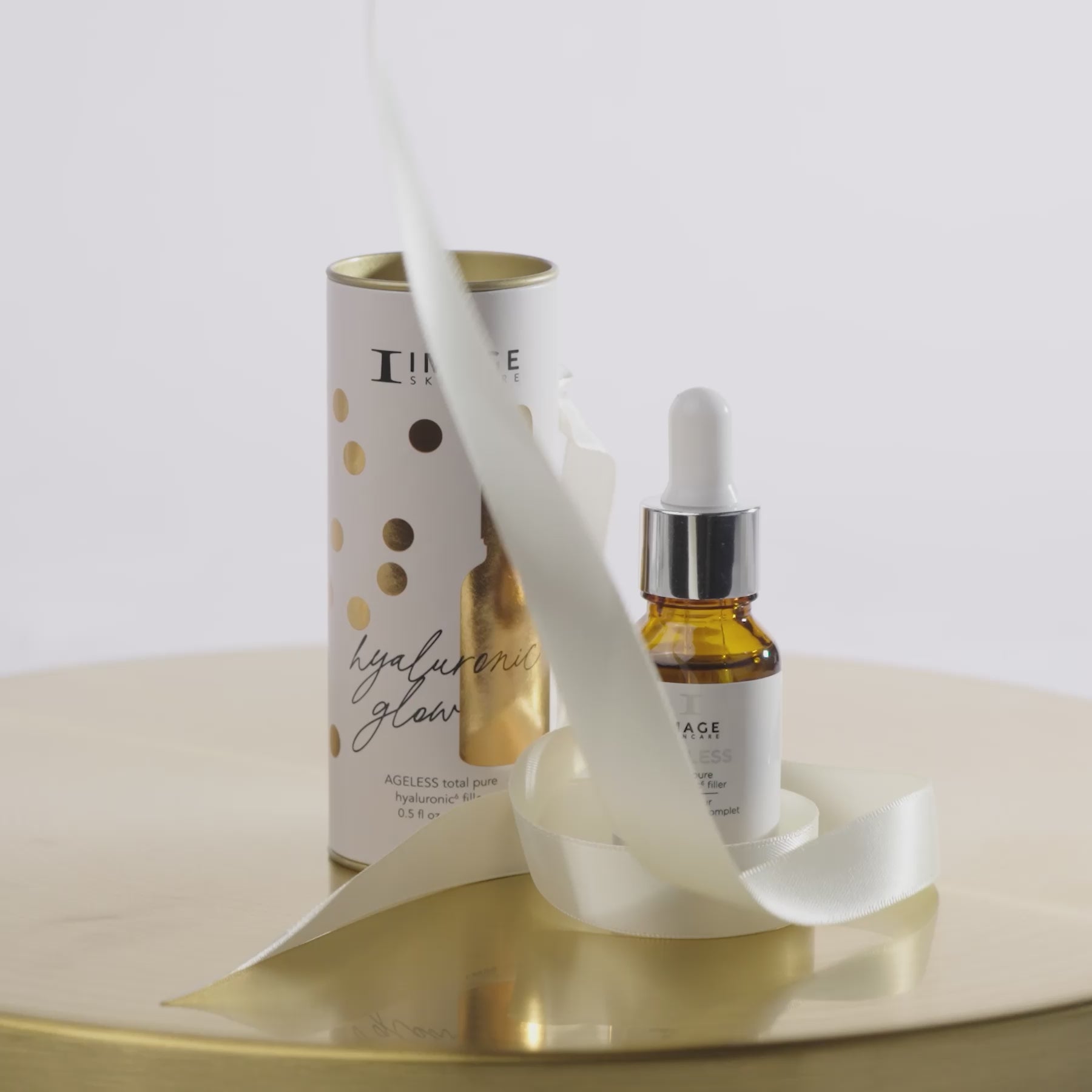 video of package and product with ribbon unraveling around the AGELESS serum