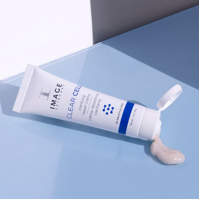 Discovery-size CLEAR CELL clarifying repair crème mini tube dispensing creme on blue background