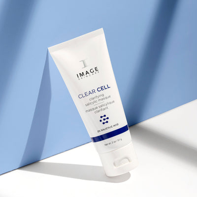 clear cell salicylic masque bottle leaning on blue wall