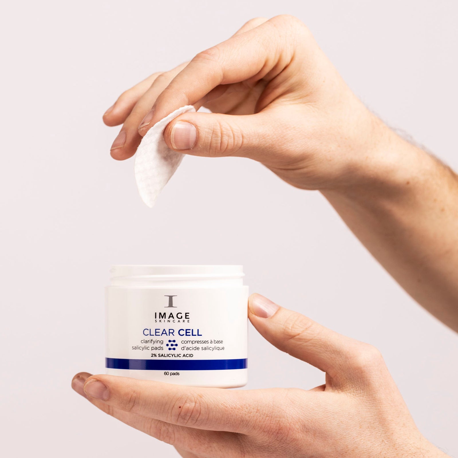 model hands pulling pad out of clear cell pad container 