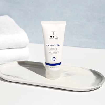 clear cell mattifying moisturizer bottle on bathroom counter