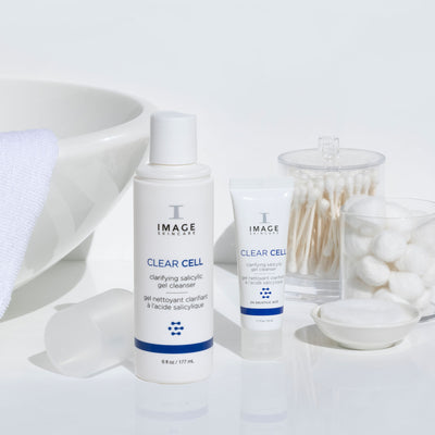 clear cell salicylic cleanser retail and travel size bottles on bathroom counter