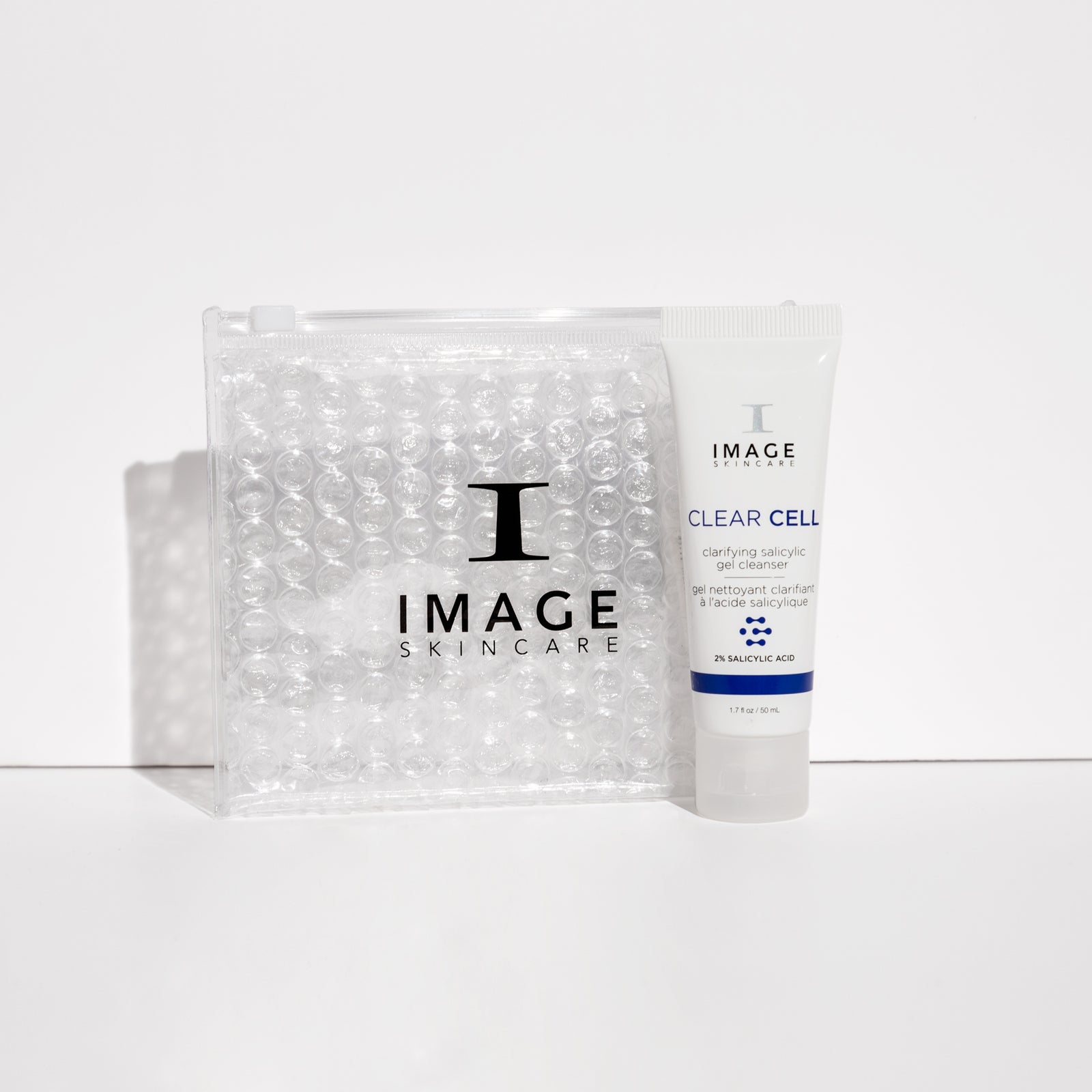clear cell cleanser travel size tube next to clear bubble bag
