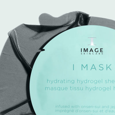 black sheet mask behind sheet mask packaging on light background