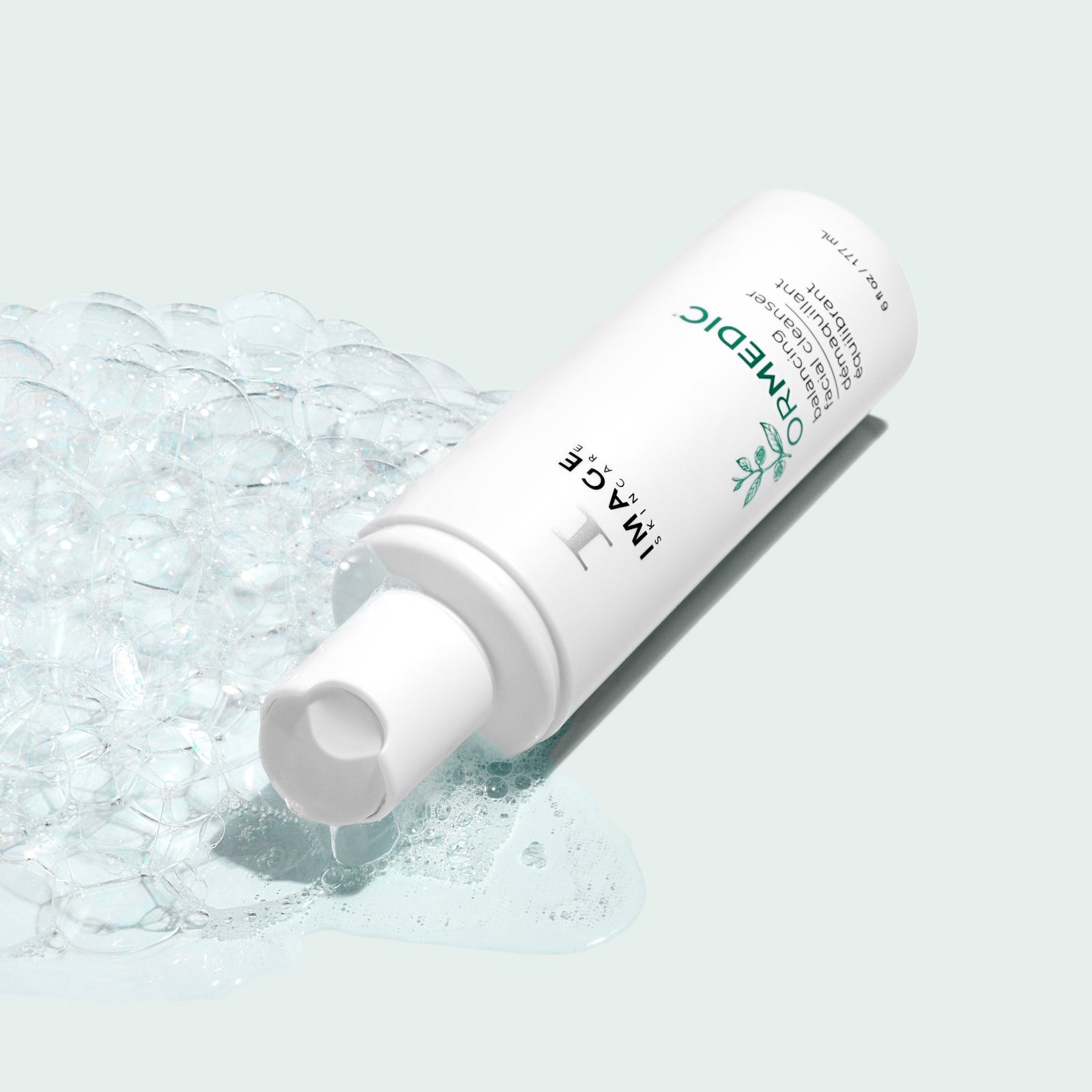 ormedic cleanser bottle opened with cleanser and bubbles pouring out on light background