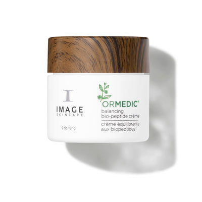 Skincare cream jar with wooden cap on a white background