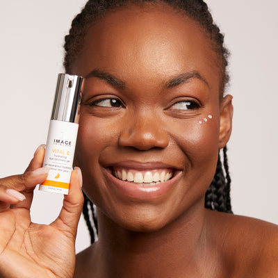 model holding eye recovery gel close to cheek