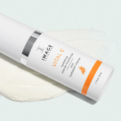 vital c moisturizer close up with product texture shot behind bottle on a light background