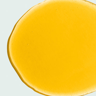 close up of yellow liquid collagen on a white background